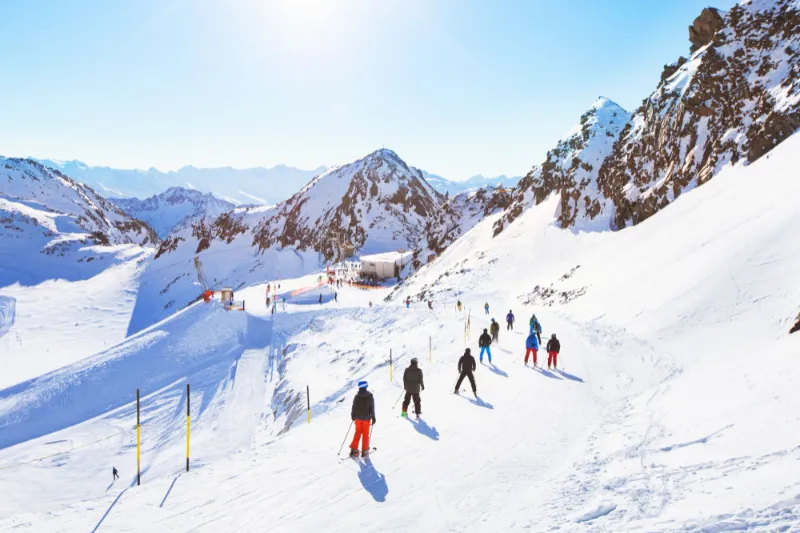 Skiers on a sunny piste high in the Austrian Alps