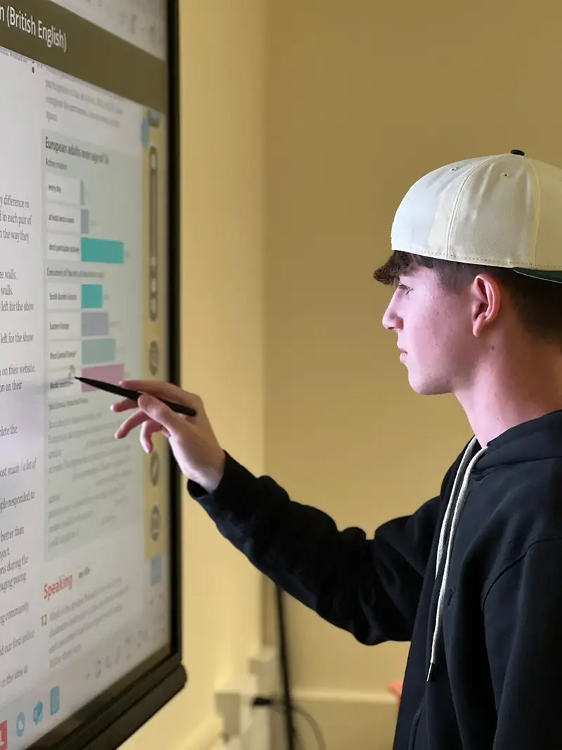 Male student using interactive screen at Southbourne School of English