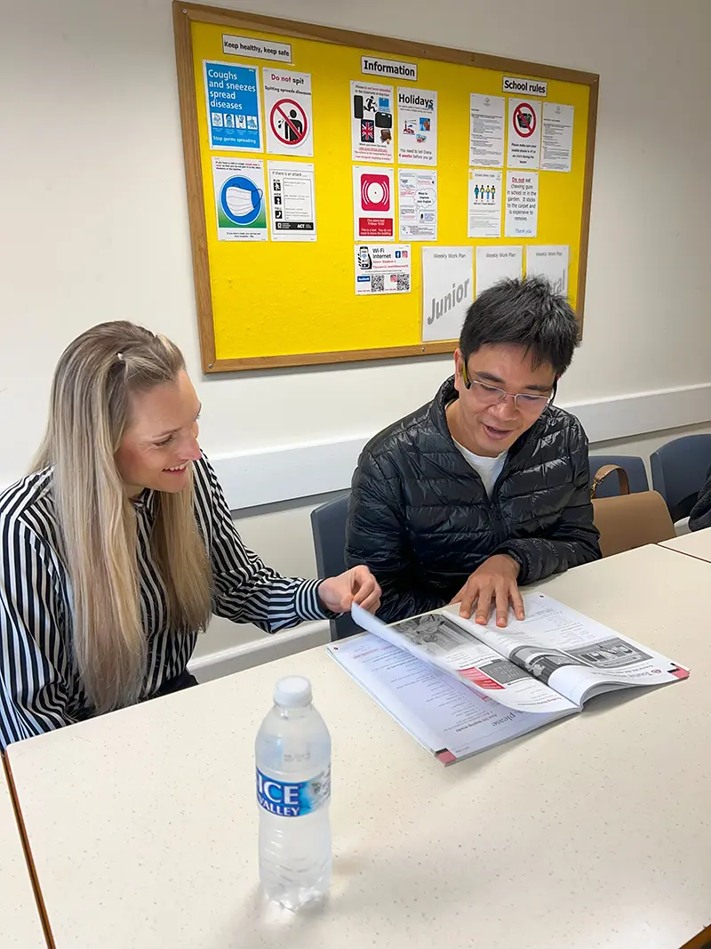 Two adult students looking at textbook at Southbourne School of English
