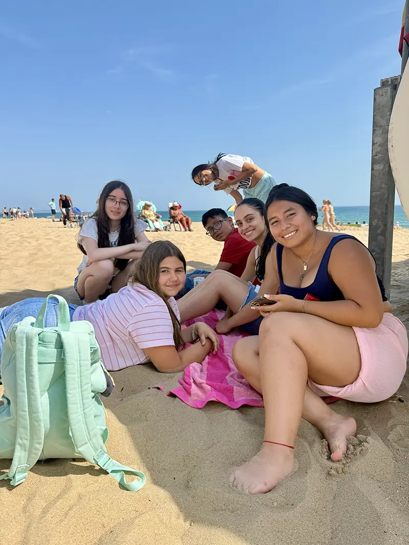Students relaxing on the beach together