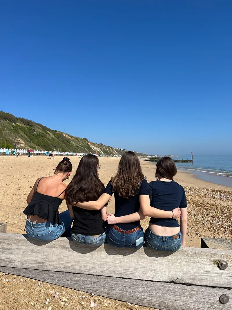 Students sat on groin on beach on a school excursion