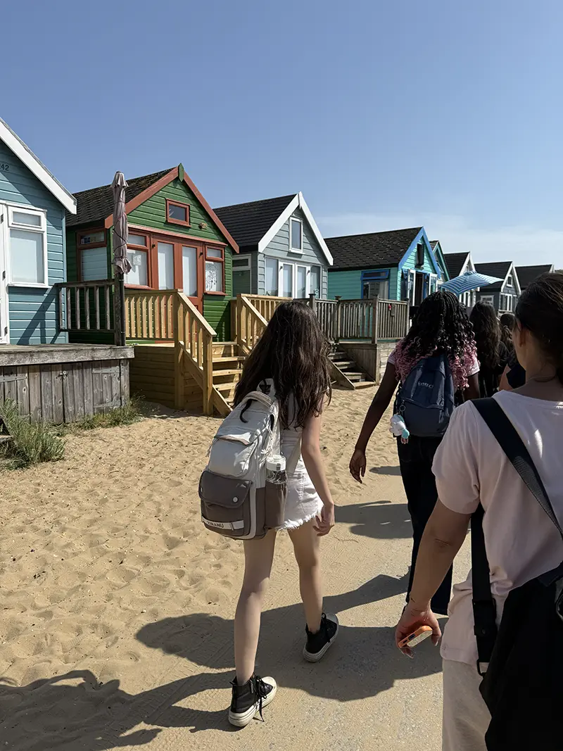 Students walking by beach huts mudeford on a school excursion