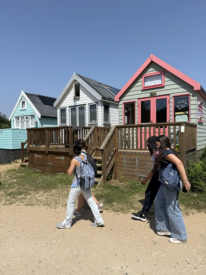 Students walking by colourful beach huts