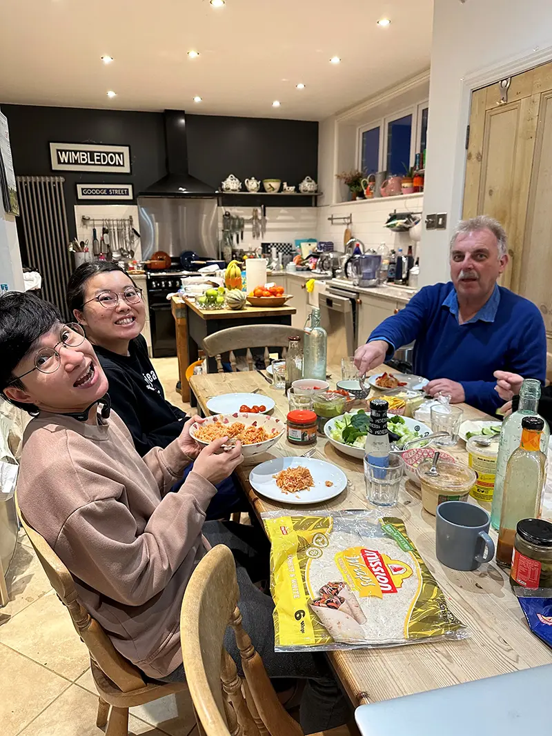 Students with homestay host at dinner in a homestay home
