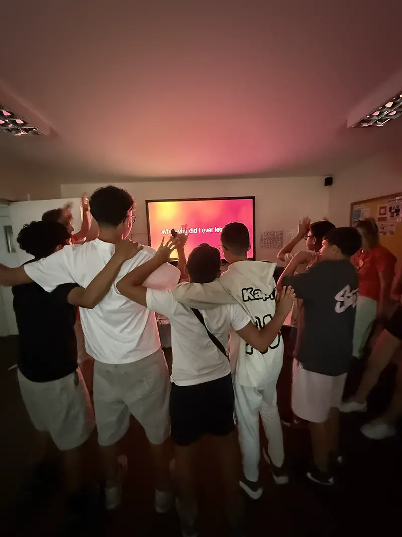 Students singing karaoke at an evening activity